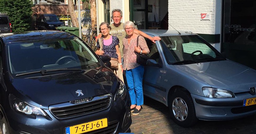 Happy customers with their car in front of the garage